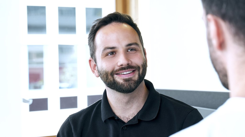 Mitarbeiter im Kundenservice im Gespräch, freundlich und hilfsbereit.